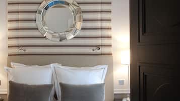 A hotel room with a bed, a circular mirror, striped curtains, and a door with the number 34.
