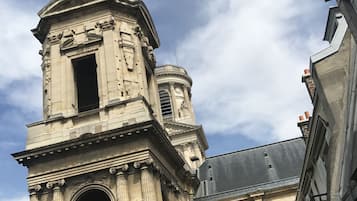 Un edificio histórico con arquitectura clásica, que incluye una torre destacada con cúpula y una entrada abovedada imponente.
