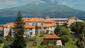 Un hotel costero con varias edificaciones, vista al mar y una montaña al fondo.