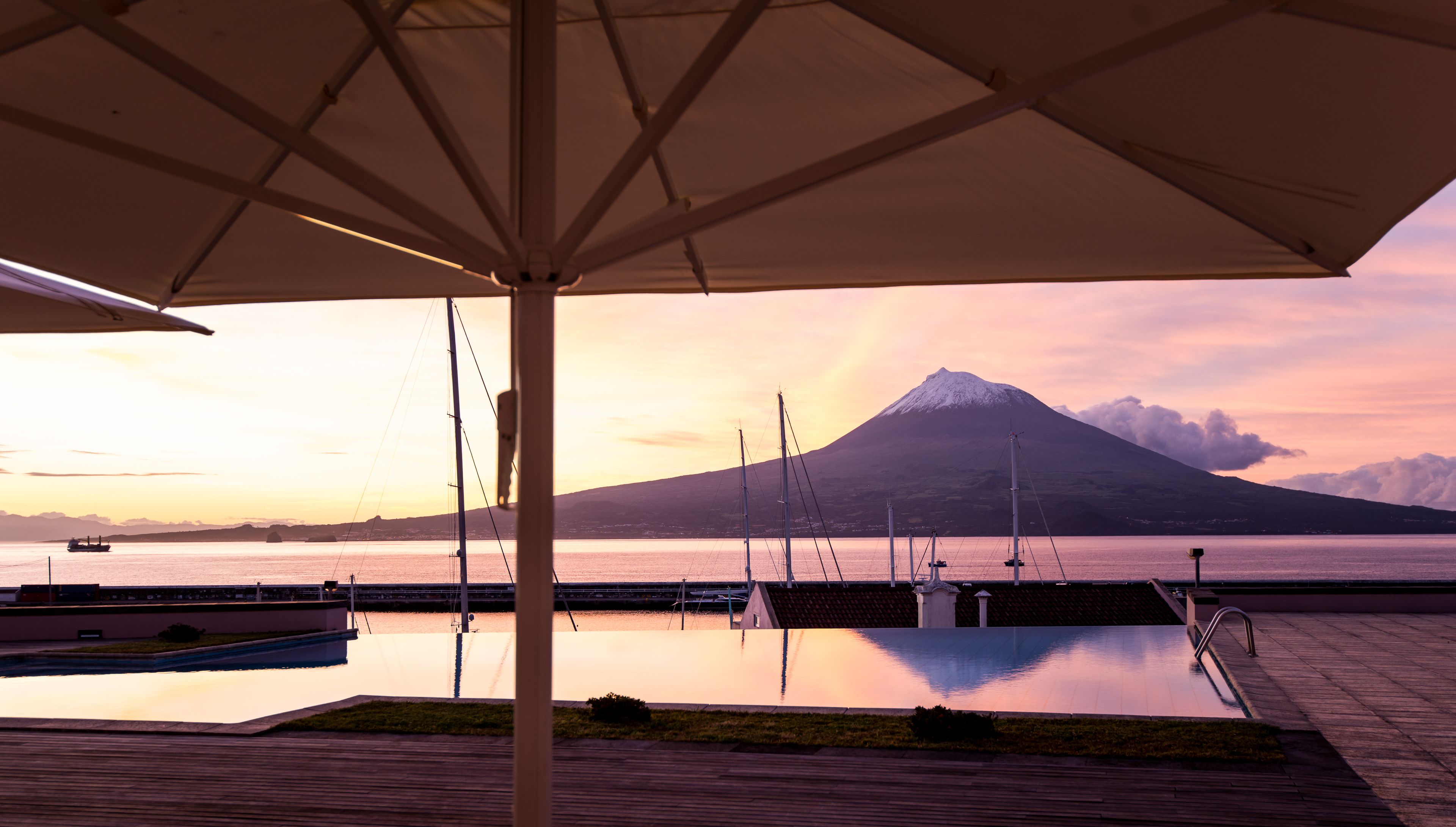 A deck with a view of a mountain and a body of water.