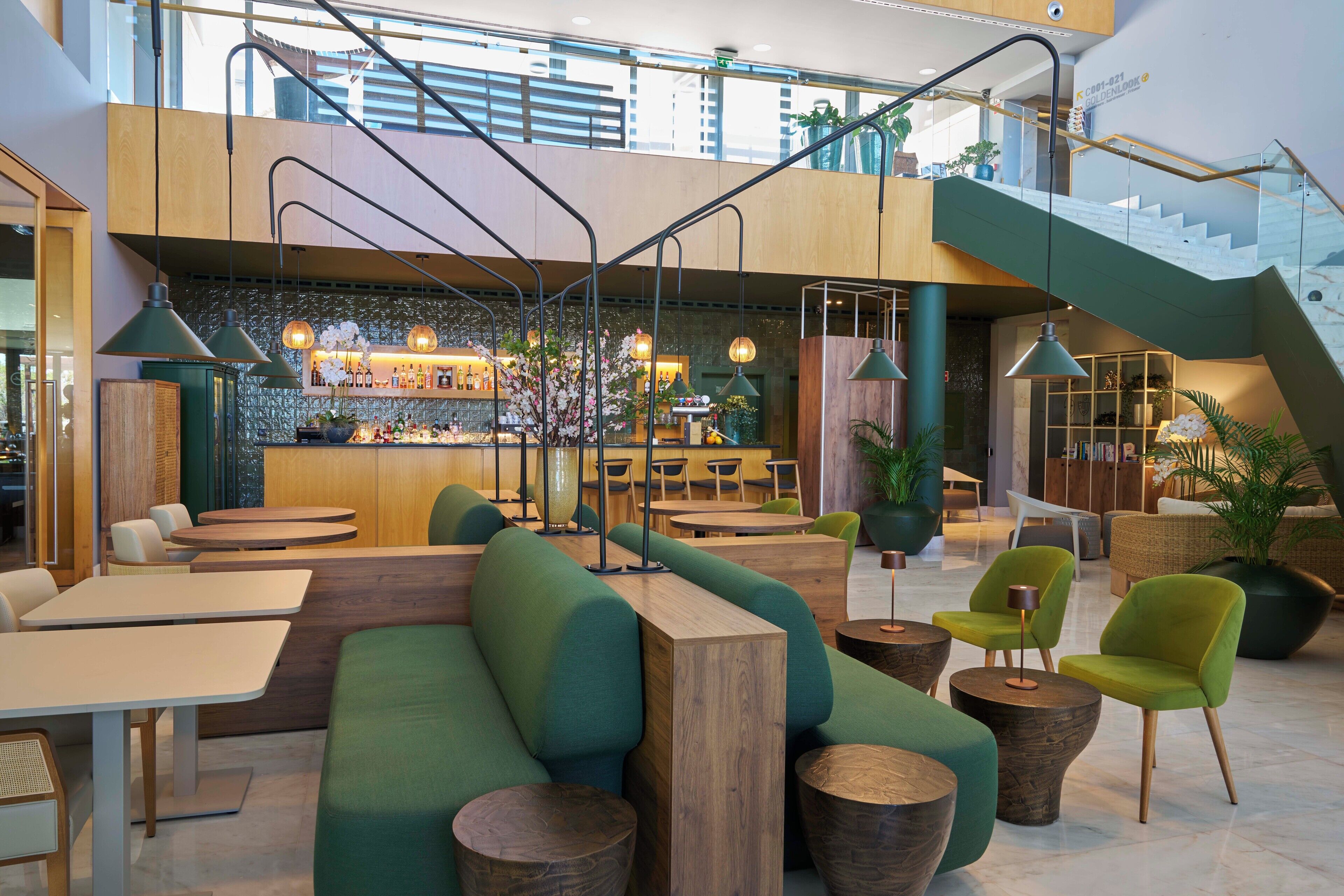 Un intérieur moderne comprenant un bar, des espaces de détente et un escalier.