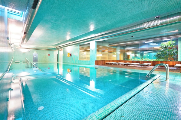 Piscine intérieure, piscine extérieure, parasols, chaises longues