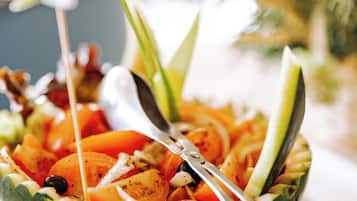 A bowl of salad with vegetables and a spoon.