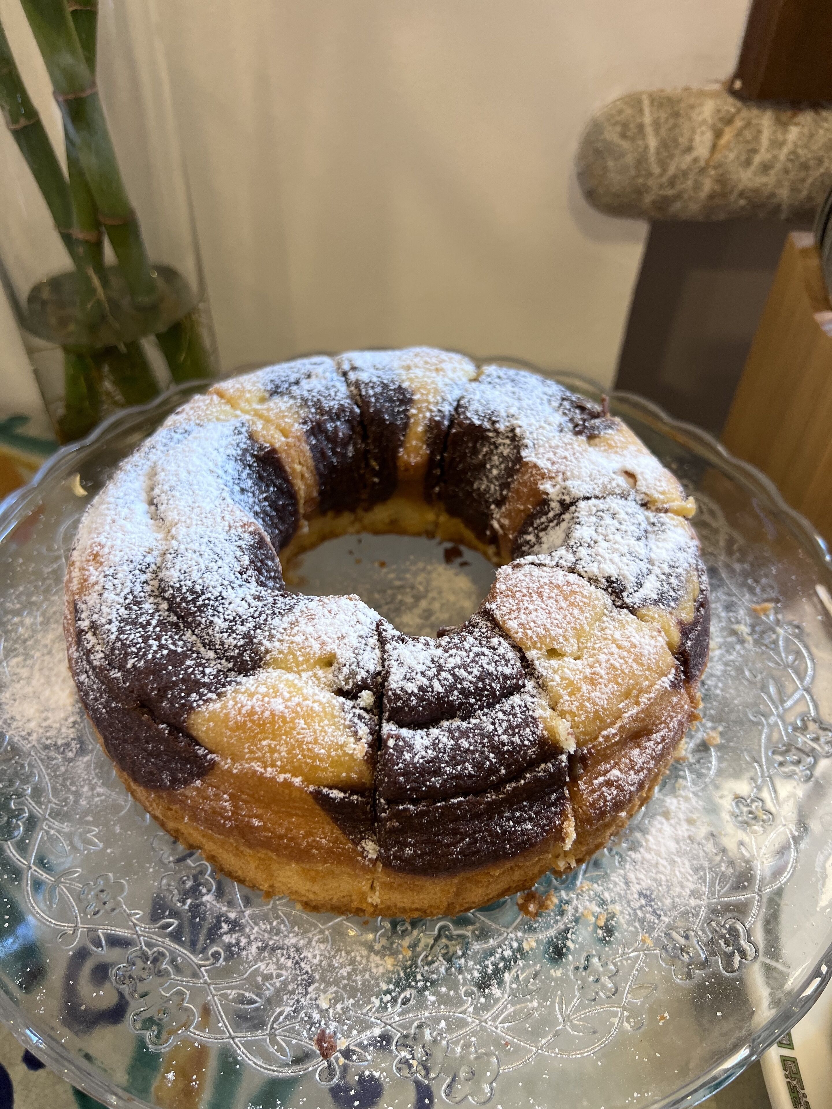 A bundt cake on a glass plate with a floral design.
