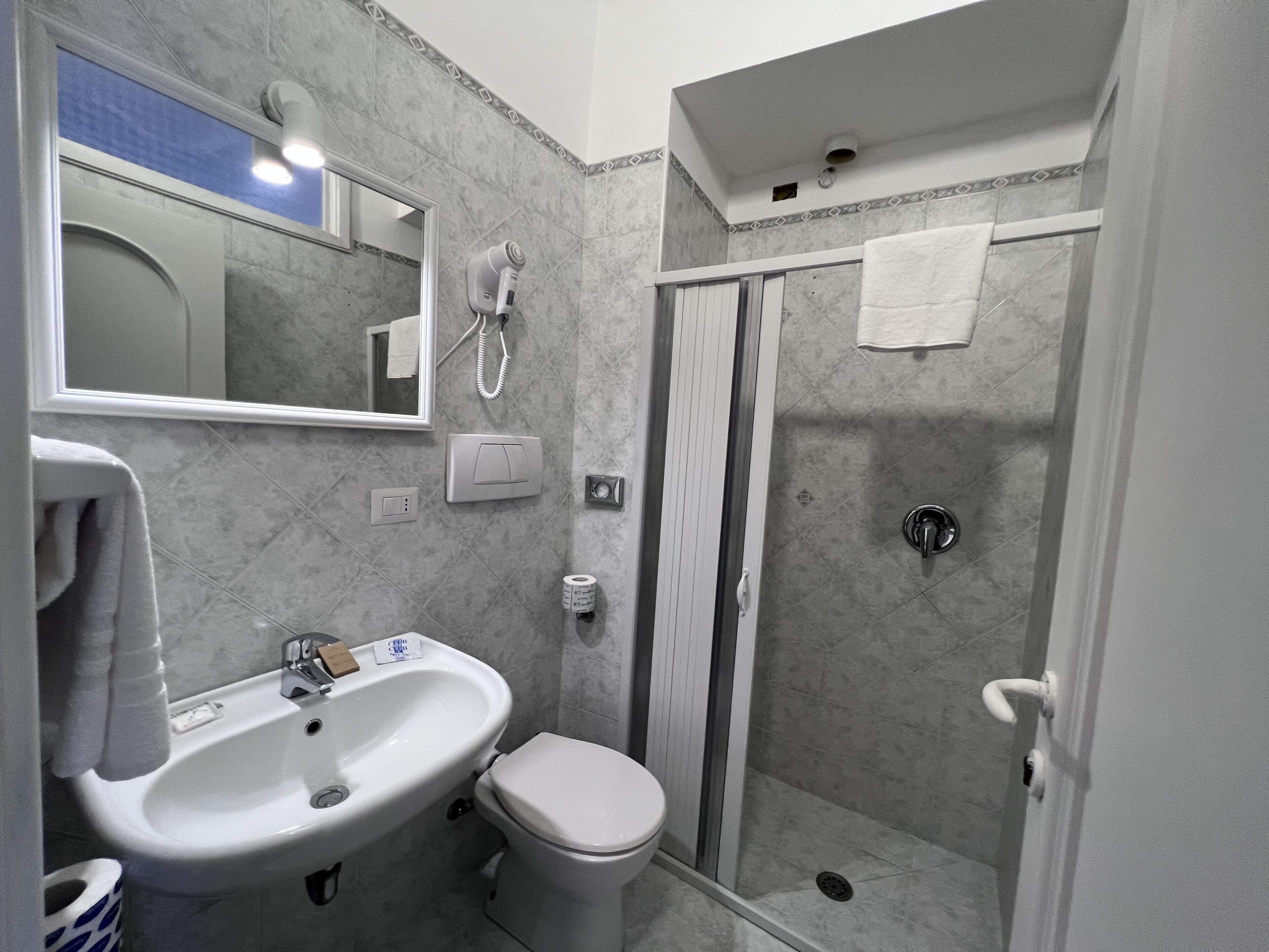 A bathroom with a sink, toilet, and shower.