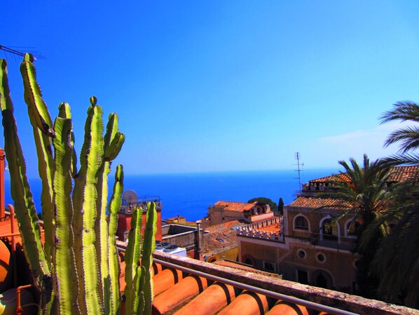 A coastal cityscape with buildings and a clear blue sky. - Hotel Villa Chiara (Taormina)