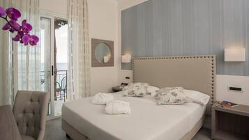 Une chambre d’hôtel avec un grand lit, une chaise, une table de chevet et une vue sur l’extérieur.