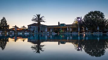 Una piscina al aire libre de temporada, sombrillas