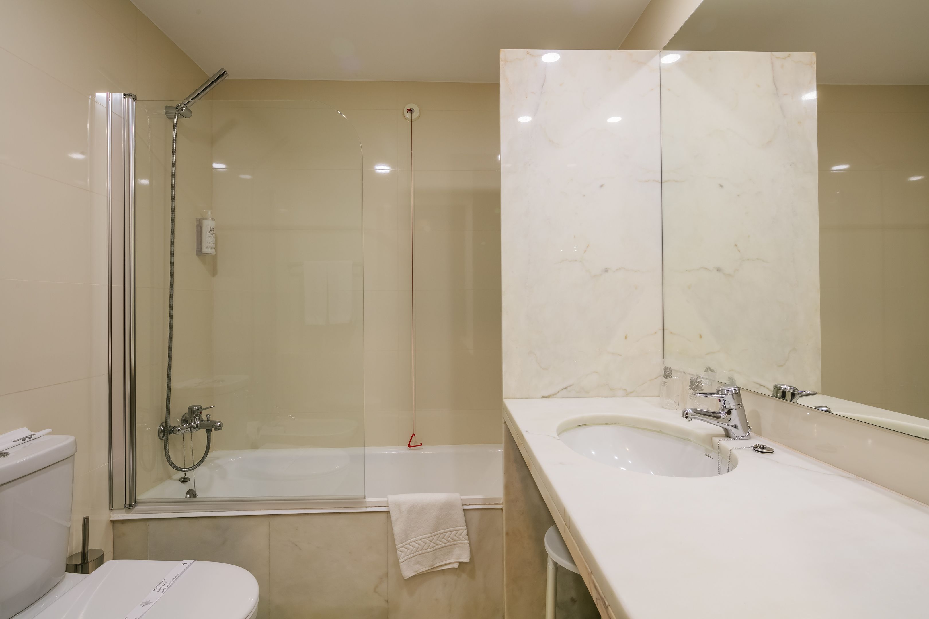 Ein modernes Badezimmer mit einer Duschkabine, einer Badewanne, einem Waschbecken und einer Toilette.