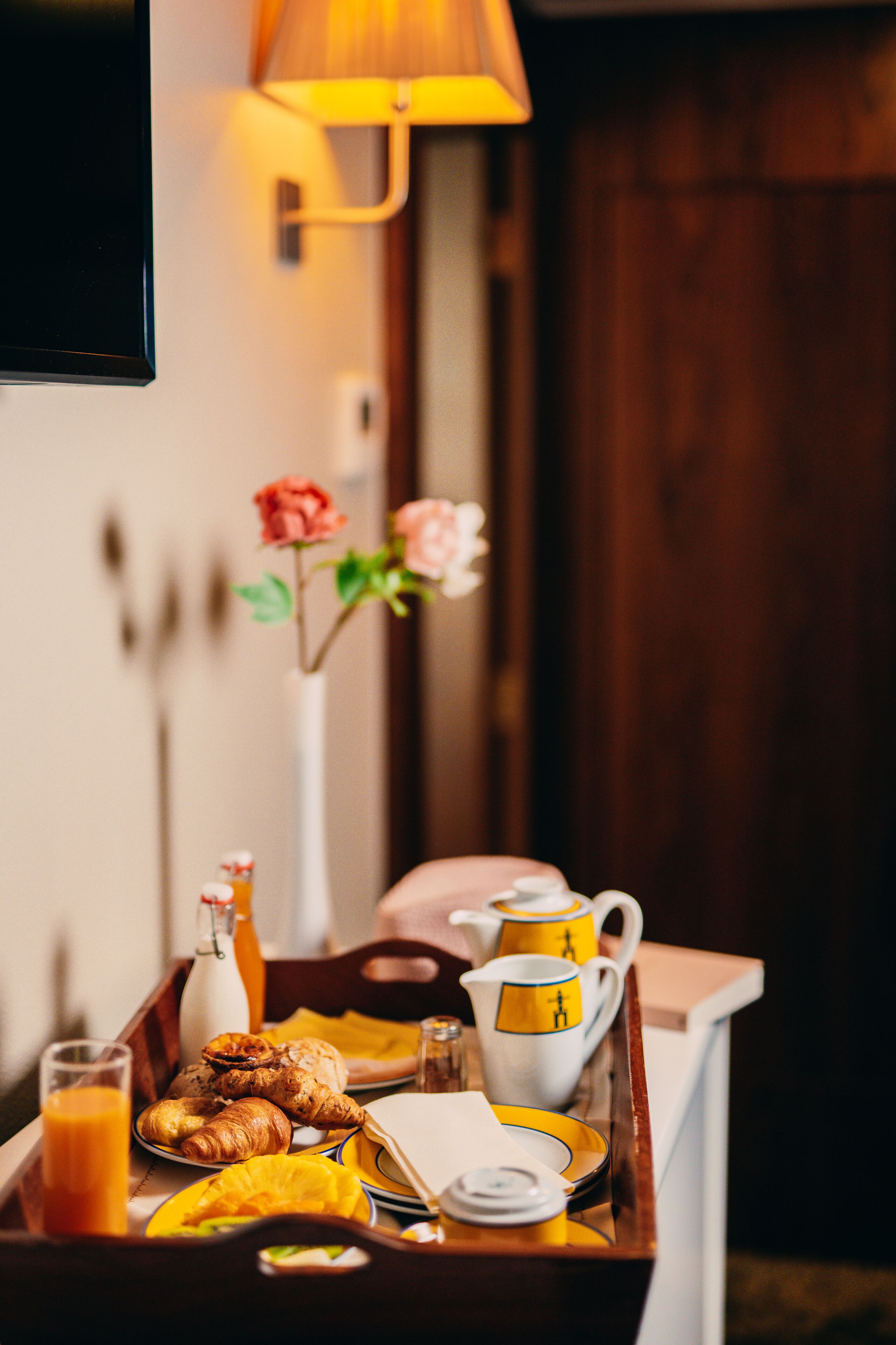 Un plateau de petit-déjeuner avec des croissants, un verre de jus d’orange et une bouteille de lait.
