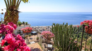 A balcony with a view of the sea, surrounded by cacti and pink flowers. - Hotel Antares (Letojanni)