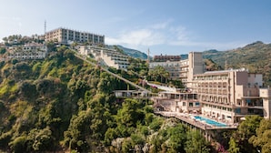 A hotel with multiple floors, a pool area, and a hillside location. - Hotel Antares (Letojanni)