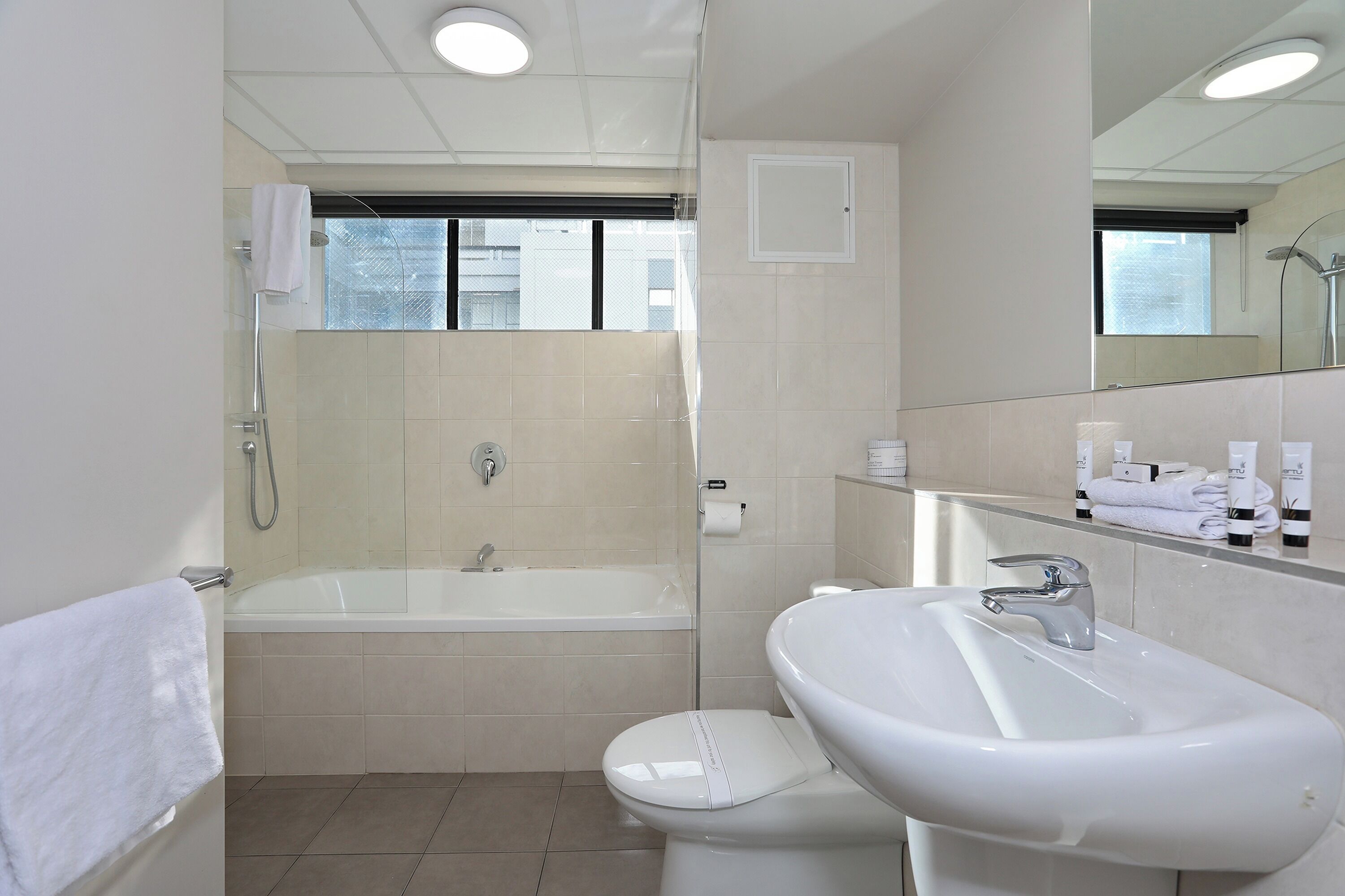 A modern bathroom with a bathtub, toilet, and sink.