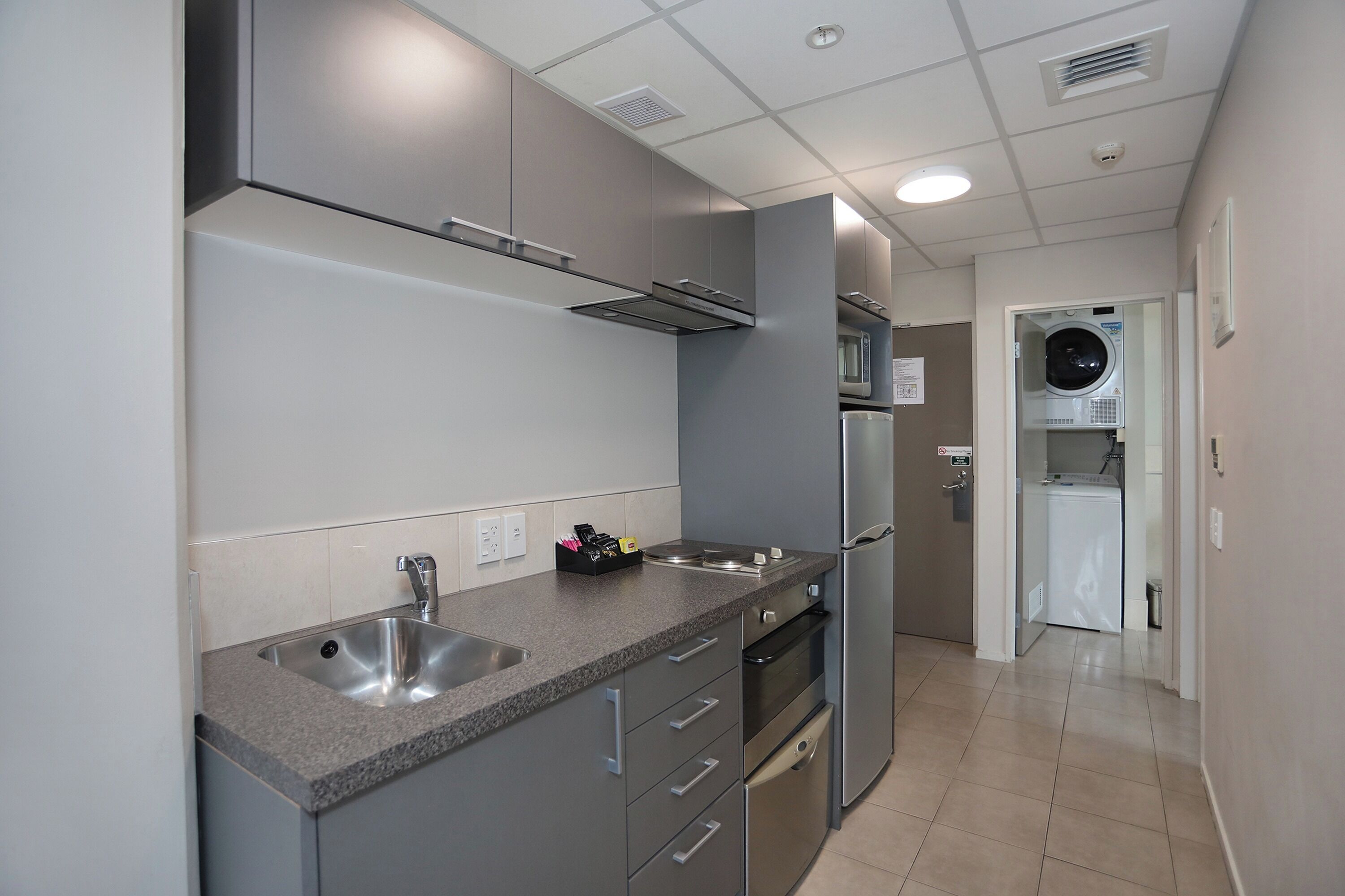 A modern kitchen with stainless steel appliances, a built-in microwave, and a dishwasher.