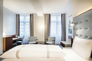 Relax in a spacious room with a large bed, desk, and comfortable seating area.