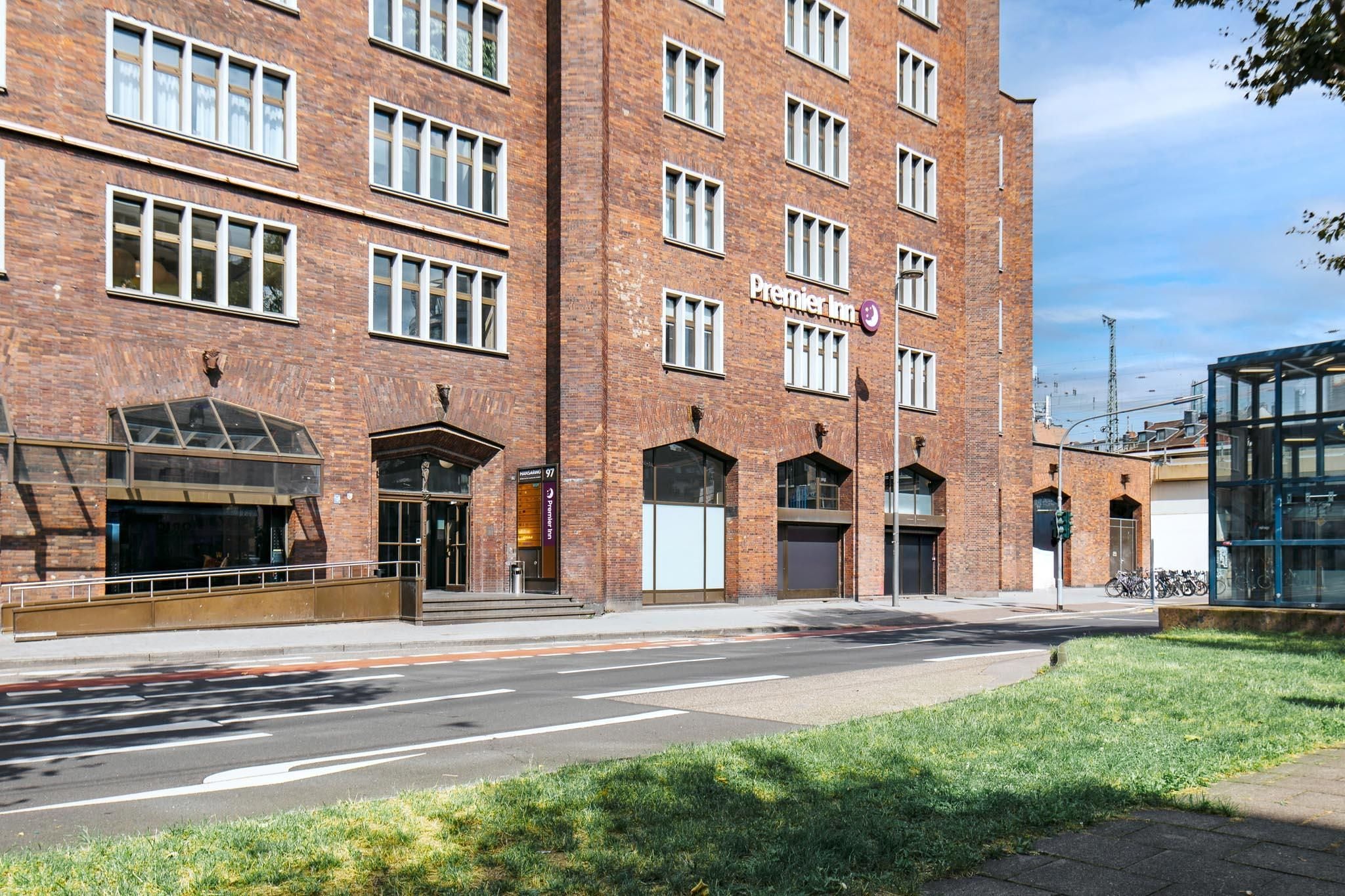 A brick building with a 'Premier Inn' sign, large windows, and a glass entrance.