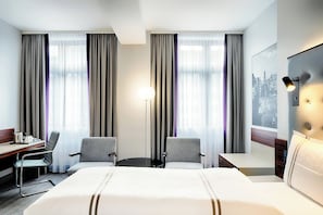 Relax in a stylish room with a large bed, two armchairs, and a flat-screen TV.