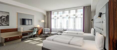 Una habitación de hotel con cama, escritorio, silla y televisor.