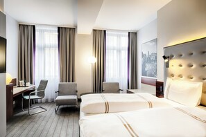 Relax in a stylish space with a large bed, desk, and comfortable seating area.