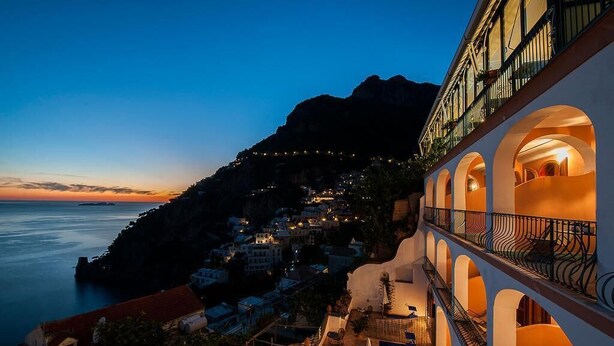 A coastal hotel with a balcony overlooking the sea and a mountainous backdrop. - Il Gabbiano (Positano)