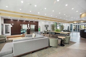 Un vestíbulo amplio con mostrador de recepción, zona de estar y comedor.