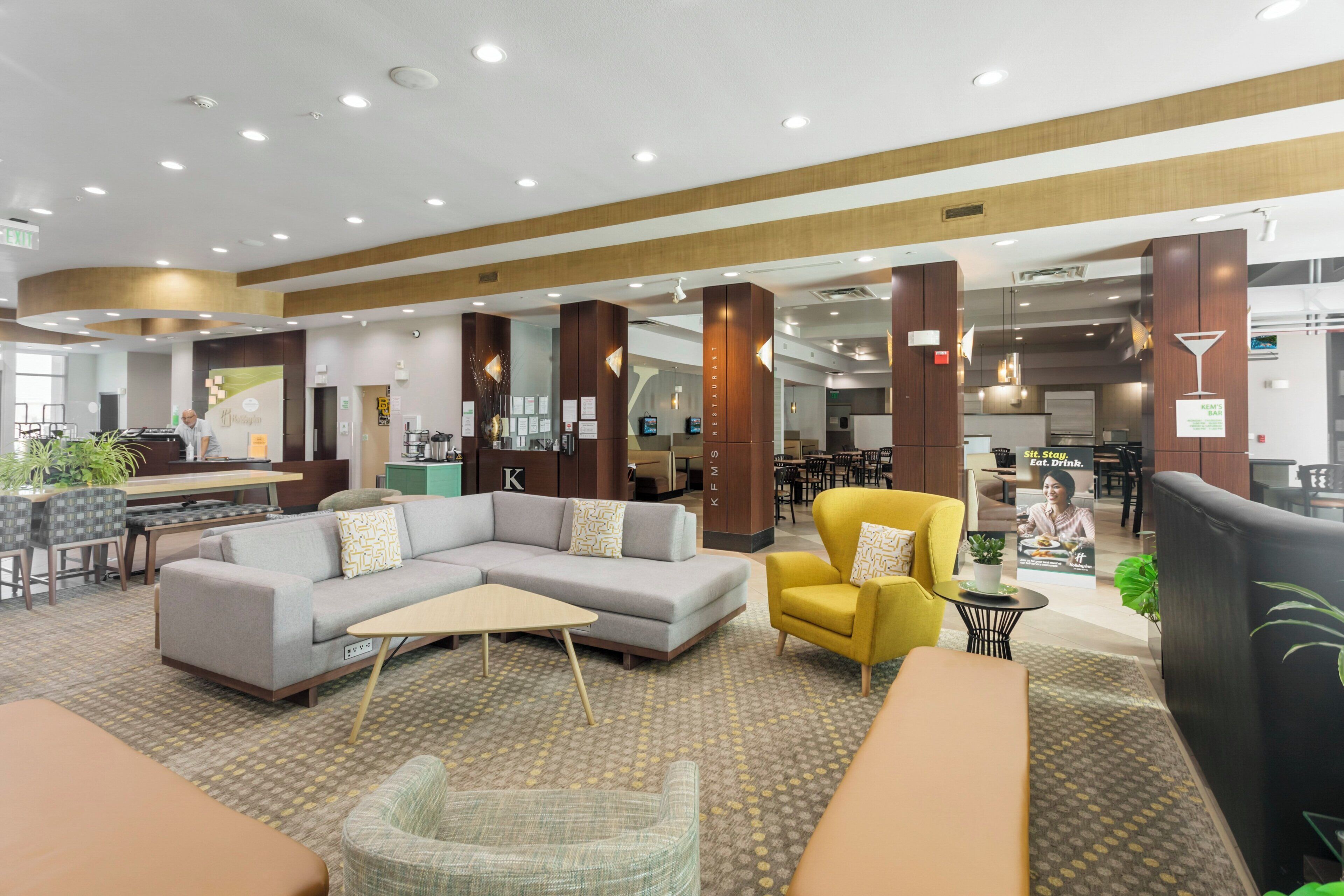 A hotel lobby with a seating area, a bar, and a restaurant.