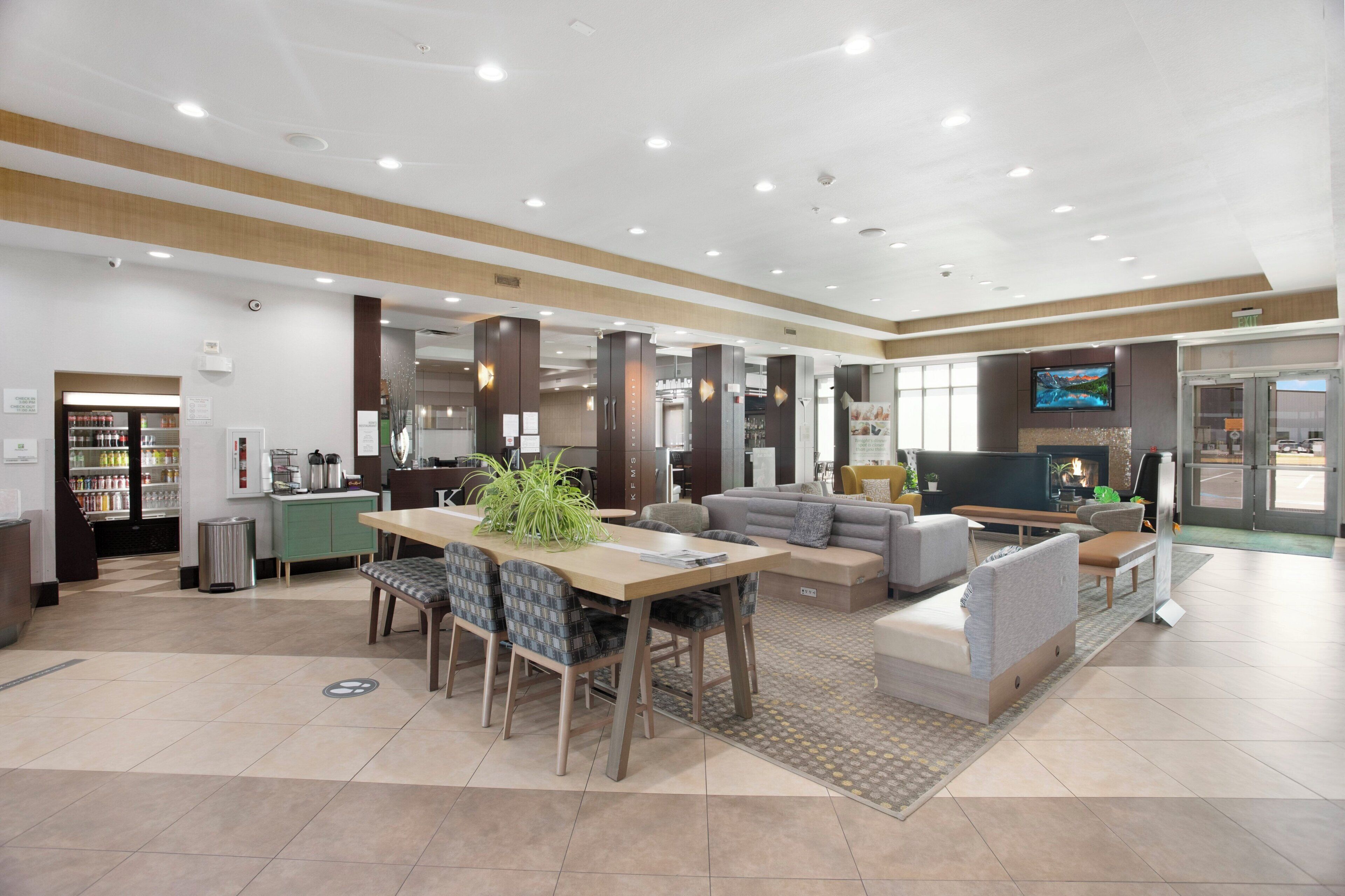 A spacious living area with a dining table, sofas, and a television.