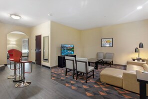 A hotel room with a TV, seating area, and a patterned carpet. - Holiday Inn Hotel & Suites Waco Northwest by IHG (Waco)