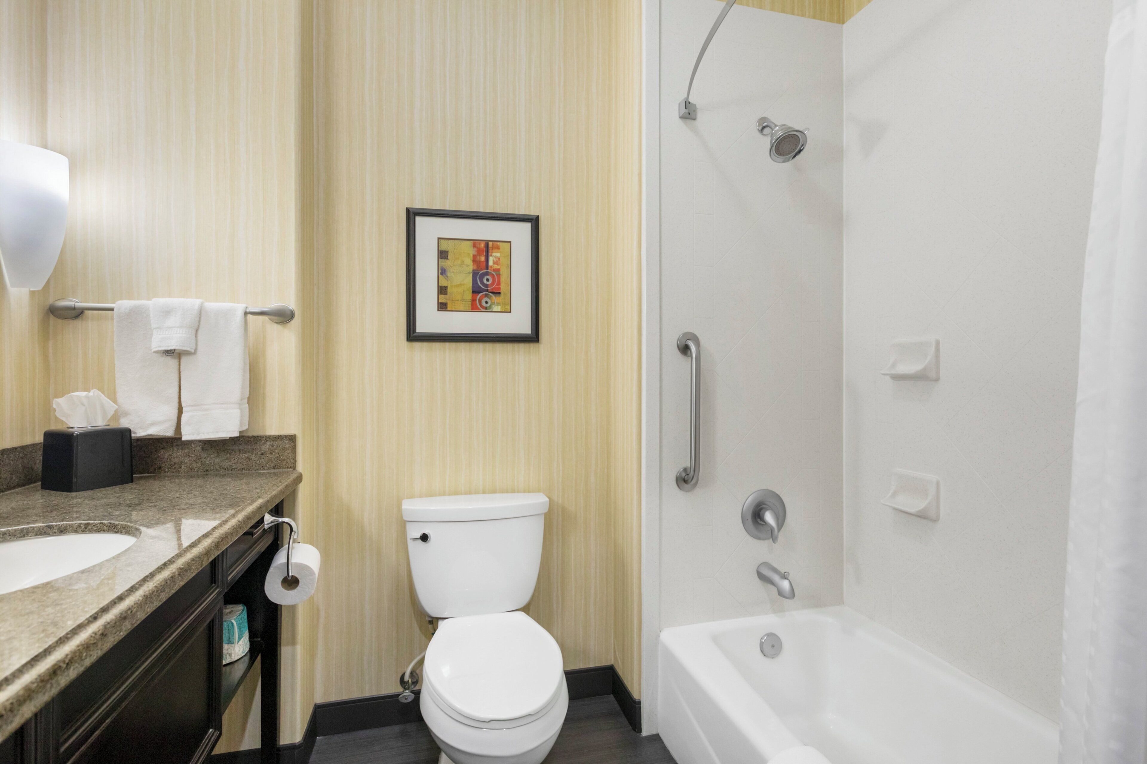 A hotel bathroom with a sink, toilet, and bathtub.