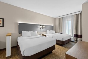 A hotel room with two beds, a bedside table, a nightstand, a desk, and a large window with curtains. - Comfort Suites Edinboro (Edinboro)