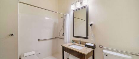 Ein Badezimmer mit begehbarer Dusche, Waschbecken mit Spiegel und Toilette.