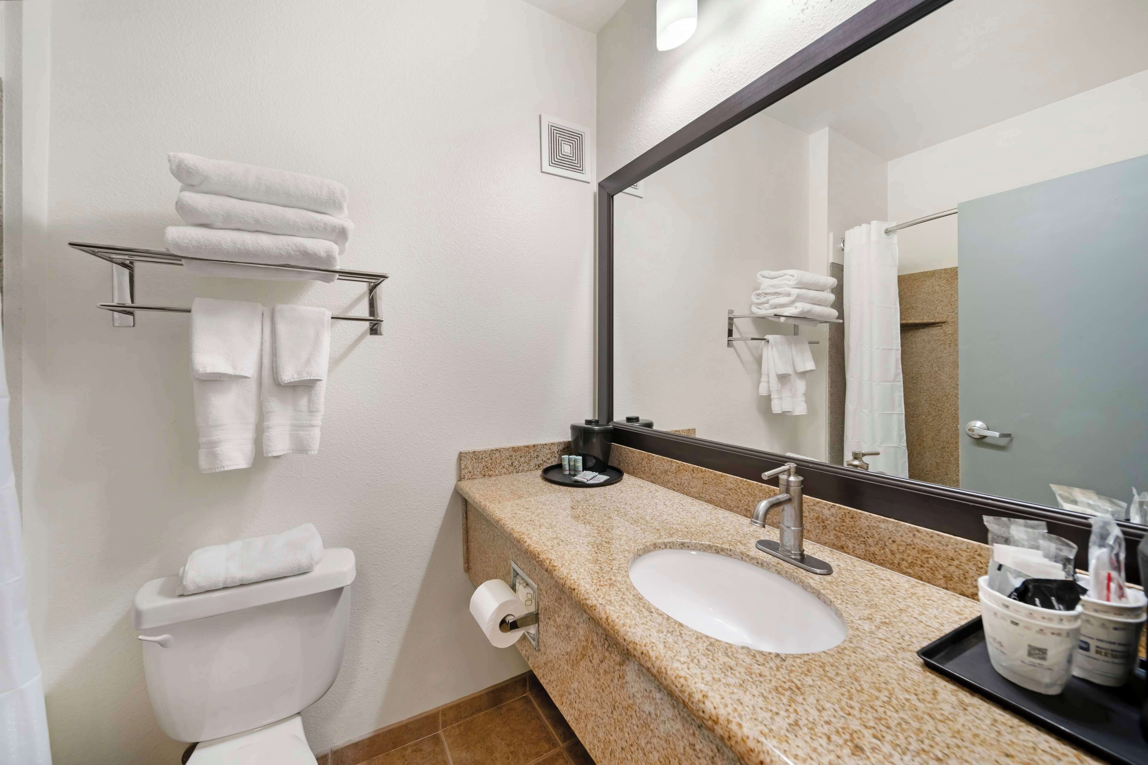 A bathroom with a white sink, a mirror, and a towel rack.