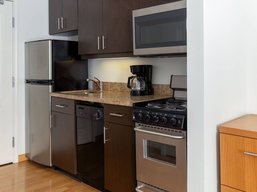 A modern kitchen with stainless steel appliances, a microwave, and a coffee maker.