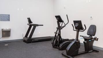 A fitness room with a treadmill, elliptical, and stationary bike.