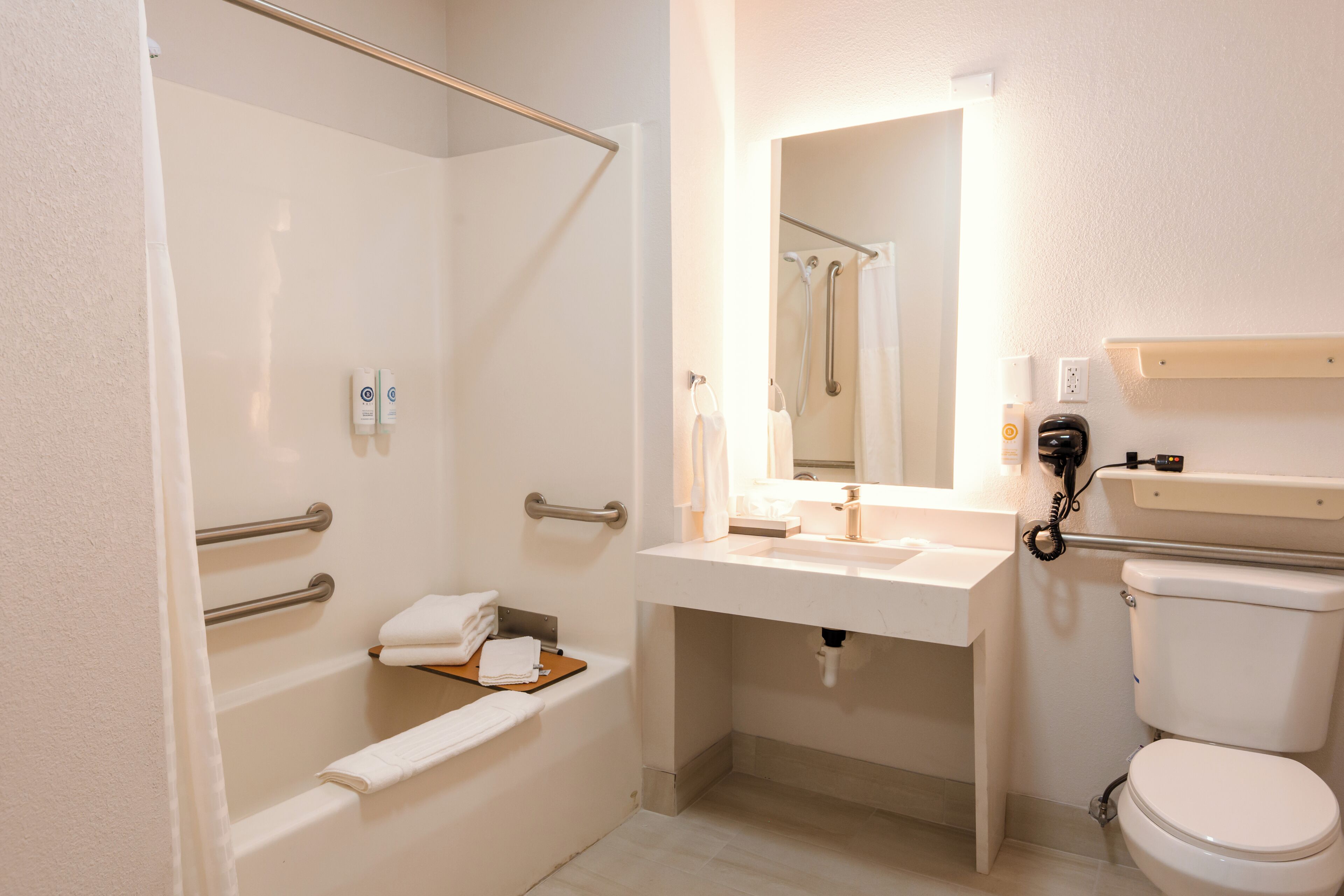 A bathroom with a bathtub, a toilet, a sink, and a mirror.