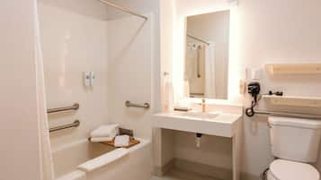 A bathroom with a bathtub, a toilet, a sink, and a mirror.