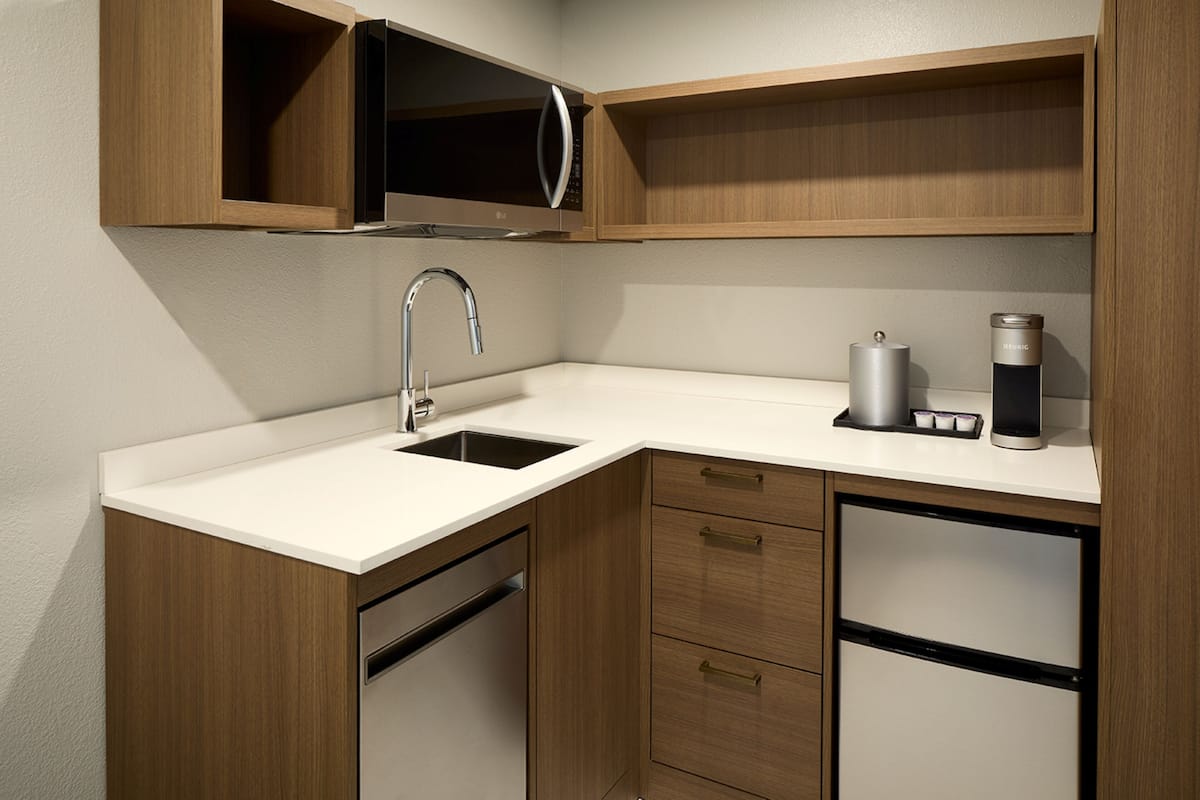 Cocina compacta con lavabo, cafetera y microondas.