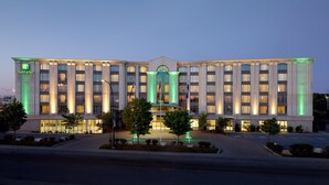 Ein mehrgeschossiges Holiday Inn Hotel mit einer symmetrischen Fassade, großen Fenstern und einem zentralen Eingang.