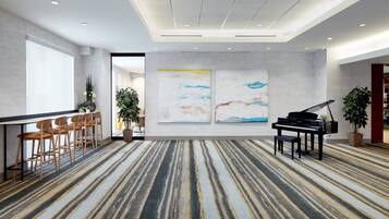 Une pièce spacieuse avec un tapis à rayures, un piano et un coin salon avec des fauteuils.