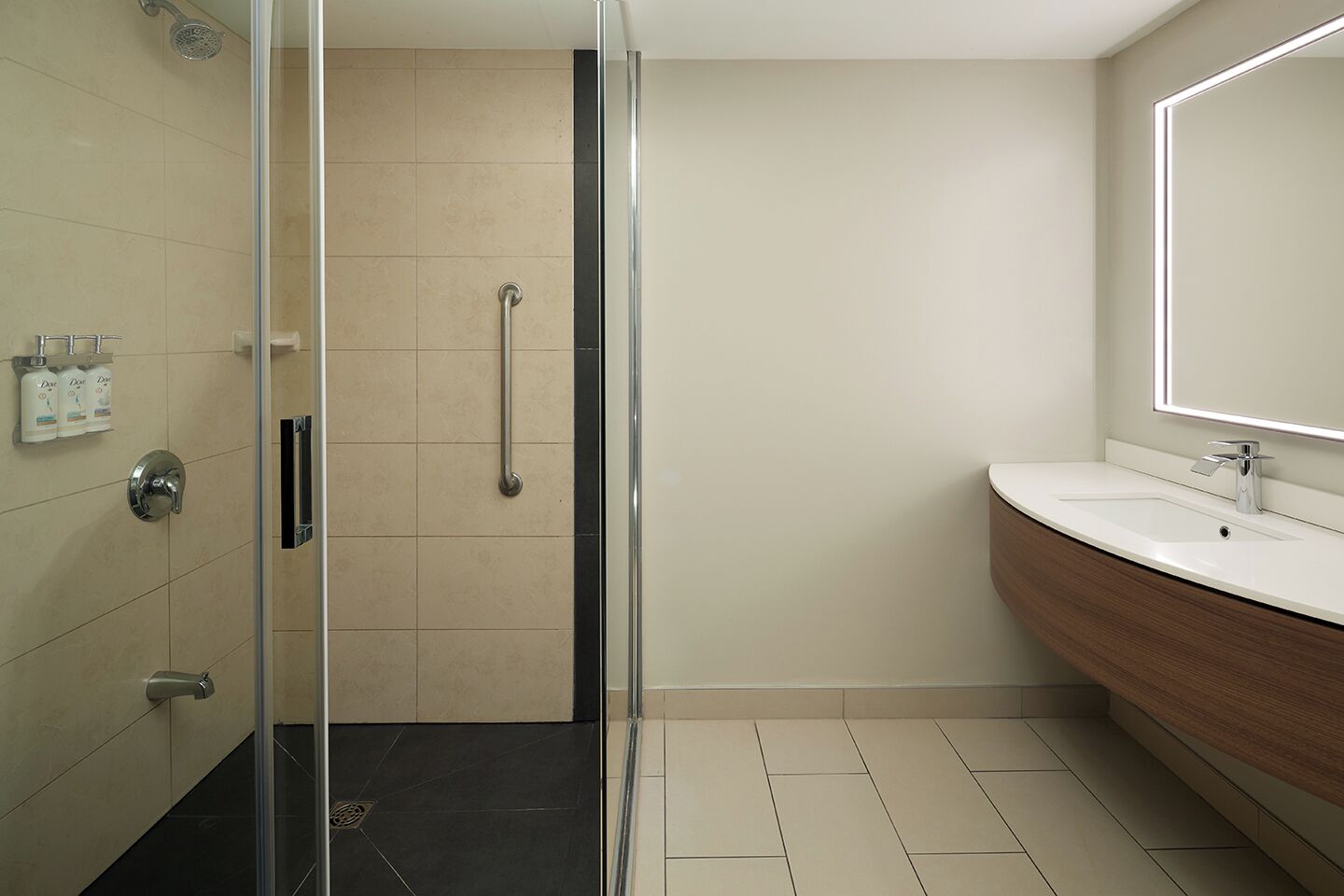 Une salle de bain moderne avec une douche à parois de verre, un meuble-lavabo avec un miroir et un évier.