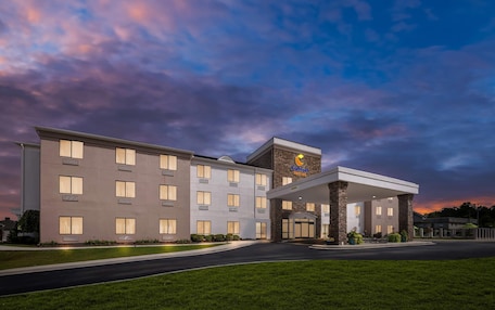 A Comfort Suites hotel with a modern design, featuring a spacious entrance and a well-lit facade.