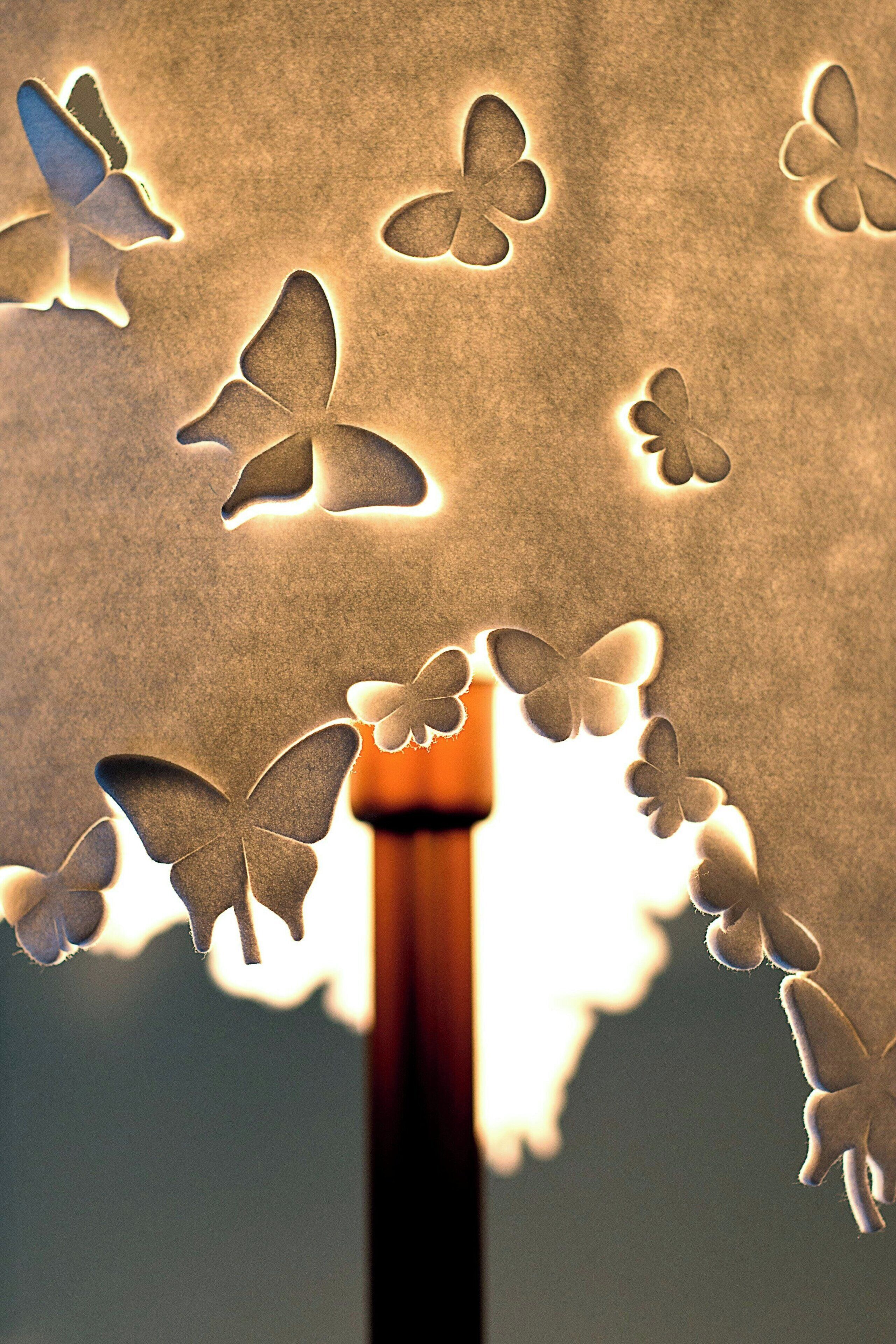 A close-up of a textured wall with butterfly cutouts.