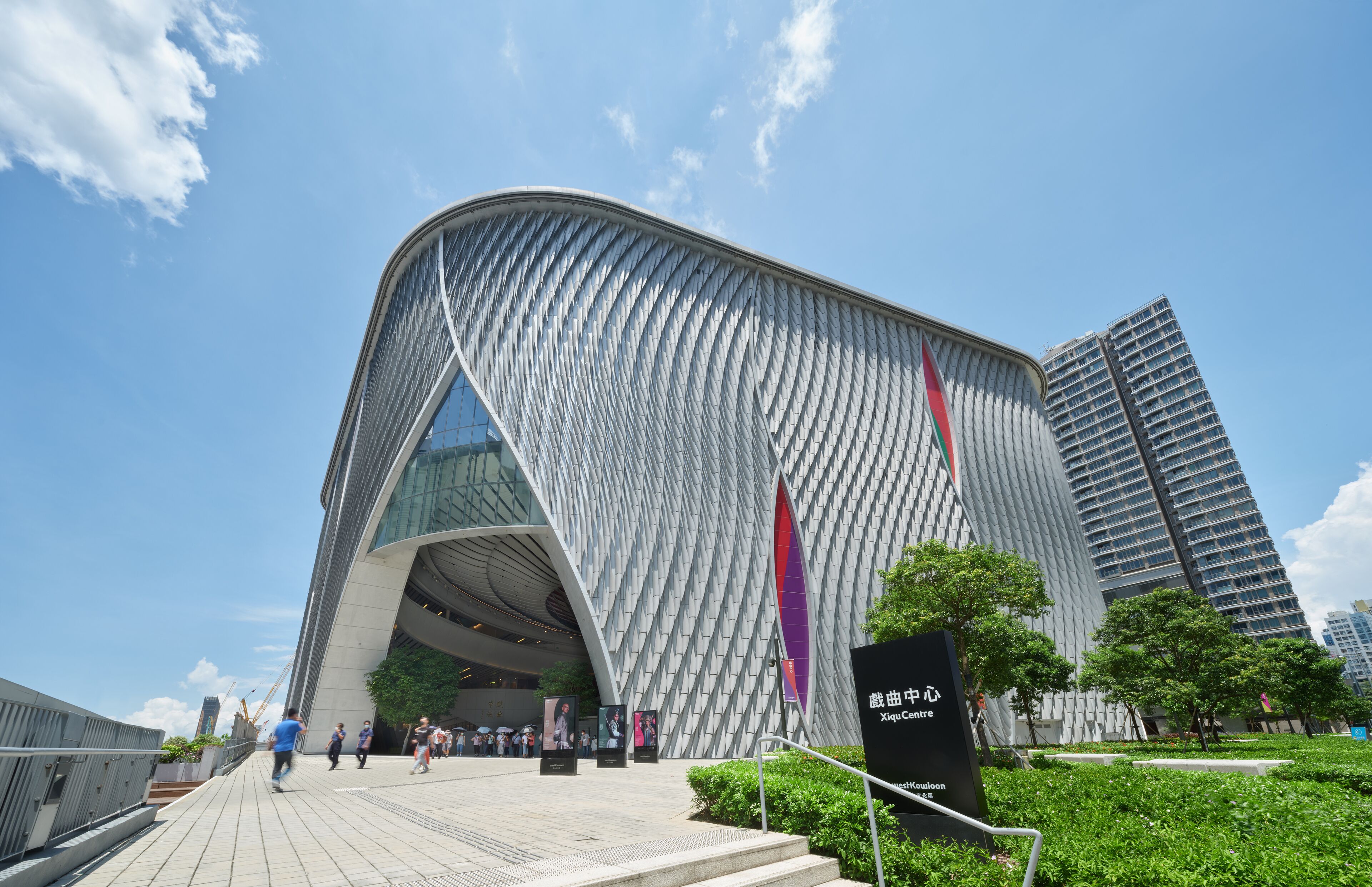 A modern building with a unique curved facade and a large entrance.