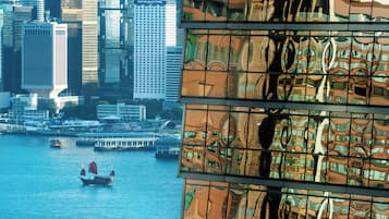 Un edificio de gran altura con una fachada singular que refleja el paisaje urbano circundante.
