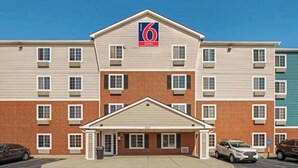 Un hôtel de 6 suites avec une façade en briques, de nombreuses fenêtres et une entrée abritée.