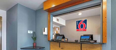 A reception desk with a blue wall, a wooden counter, and a sign indicating '6 suites.'