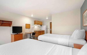 A hotel room with two beds, a desk with a chair, a television, and a kitchenette. - Studio 6 Extended Stay Cincinnati Sharonville OH (Sharonville)