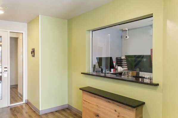 A bathroom with a mirror, a vanity, and a door leading to another room.