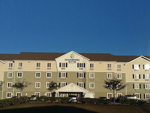 A multi-story hotel with a flat roof and a sign reading "Woodspring Suites". - WoodSpring Suites Houston I-45 Airtex (Houston)