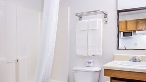A bathroom with a toilet, a sink, a shower curtain, and a towel rack.